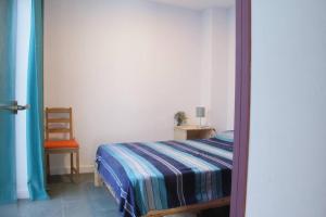 um quarto com uma cama e uma cadeira num quarto em Tranquilidad y Naturaleza. Entre Volcanes y Mar em Presillas Bajas