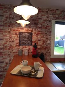 a table with a tray with two cups on it at Les Malvas in Romorantin