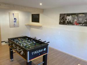 a ping pong table in front of a wall at Ferienwohnung Rotmesnerhof Seeblick in Schliersee