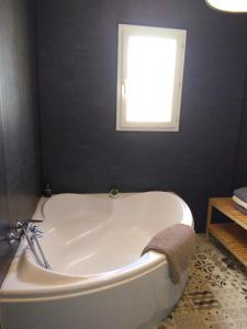 a white bath tub in a bathroom with a window at Les Malvas in Romorantin