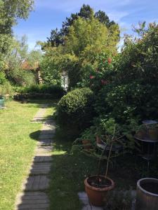 einen Garten mit einem Tisch und einigen Pflanzen und Bäumen in der Unterkunft Maisonnette Nantes in Nantes
