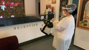 a woman wearing a mask standing at a hair salon at Cmr Aydogan Hotel in Rize