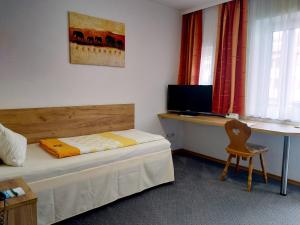 
a hotel room with a bed and a television at Hotel Fortuna in Bad Gögging
