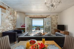 uma sala de estar com um sofá e uma mesa com fruta em Trapezaki Garden Villas em Kefalonia
