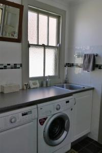 a kitchen with a washing machine and a sink at A Market Place Mudgee in Mudgee