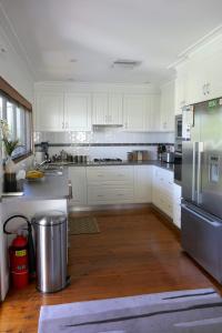 a kitchen with white cabinets and a stainless steel refrigerator at A Market Place Mudgee in Mudgee