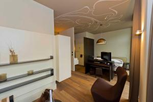 a living room with a desk and a bedroom at Bellevue-Terminus - Urban Lifestyle Hotel in Engelberg