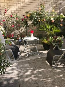 einen Tisch und Stühle in einem Garten mit Blumen in der Unterkunft Wohnen mitten in Oberhausen, Nähe Centro in Oberhausen