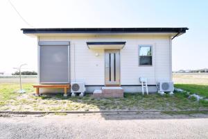 a small white house with two chairs in front of it at Endless Summer in Shirako