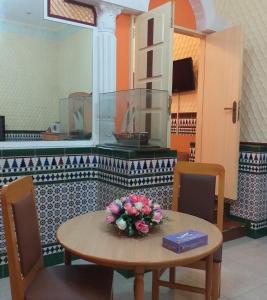 einen Tisch mit einer Blumenvase drauf in der Unterkunft Bowshar International Hotel in Muscat