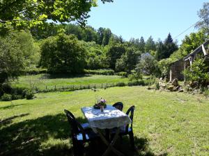 una mesa con un jarrón en un patio en Les Bouaux, Bardon, en Cussy-en-Morvan