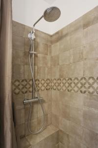a shower with a shower head in a bathroom at SunRise Cassis in Cassis