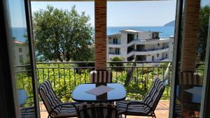 een patio met een tafel en stoelen op een balkon bij Apartments Abramovic 2 in Sutomore