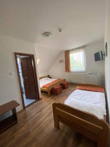 a bedroom with two beds and a window at Napház Panzió in Tiszafüred