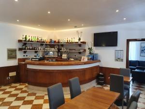 a bar in a restaurant with tables and chairs at Hotel Sole in Eraclea Mare