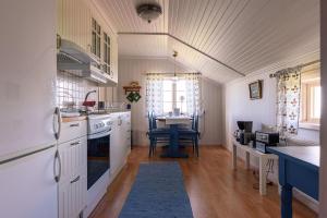 a kitchen with white cabinets and a table in it at Soltägtgården in Tällberg