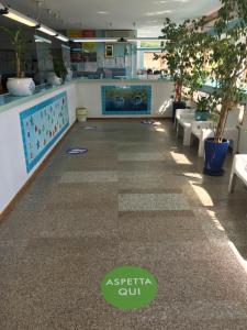 a lobby of a restaurant with tables and chairs at Centro Vacanze Cugnana Verde in Marina di Portisco