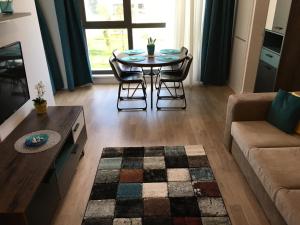 - un salon avec une table, des chaises et un canapé dans l'établissement Adams Apartment Onix Blue, à Mamaia Nord – Năvodari