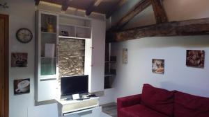 Una sala de estar con un sofá rojo y una ventana. en La casa del Ciodo, en Colico