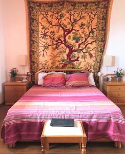 a bedroom with a large bed with a tapestry at WIFI TENERIFE SUR GUEST HOUSE in Granadilla de Abona