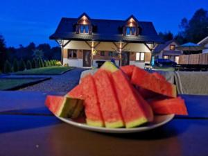 a plate of watermelon slices on a table in front of a house at Słoneczna Polana in Solina