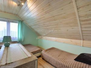 1 dormitorio con 2 camas y techo de madera en Słoneczna Polana, en Solina