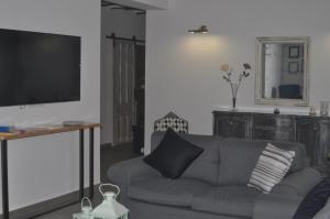 a living room with a couch and a flat screen tv at Casa Chirreas in Caravaca de la Cruz