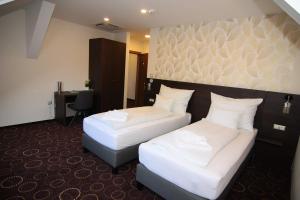 Postel nebo postele na pokoji v ubytování Vácz Hotel