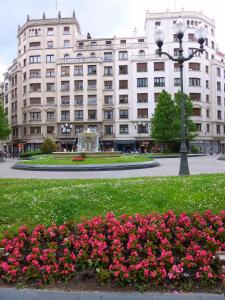 a large building with a fountain and flowers in front of it at Habitación con baño individual in Bilbao