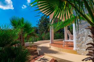 a white chair sitting on a porch with palm trees at Oasi Di Casablanca in Lampedusa