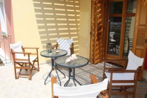 patio ze stołem i krzesłami na ganku w obiekcie Villa Alexandros w mieście Zóla