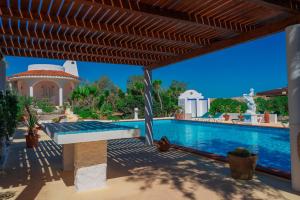 a house with a swimming pool with a wooden pergola at Oasi Di Casablanca in Lampedusa