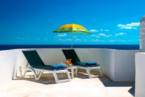 two chairs and a table with an umbrella at Oasi Di Casablanca in Lampedusa
