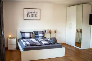 a bedroom with a bed in a white room at BoardingHouse Neuburg in Neuburg an der Donau