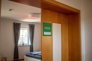 ein Schlafzimmer mit einer Tür mit einem grünen Schild darauf in der Unterkunft BoardingHouse Neuburg in Neuburg an der Donau
