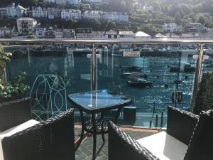 a table on a balcony with a view of the water at Shellseekers Guest House in Looe