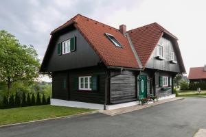 a black house with a red roof at Ferienhaus Stoiser in Sankt Stefan ob Stainz
