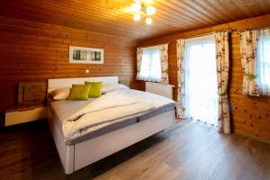 een slaapkamer met een bed in een houten hut bij Ferienhaus Stoiser in Sankt Stefan ob Stainz