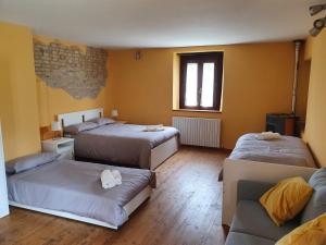 a room with three beds and a couch and a window at I Balzani B&B in Matelica
