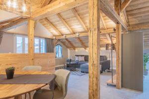 uma sala de jantar e sala de estar com tectos em madeira em Buche em Interlaken