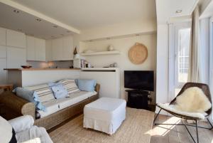 uma sala de estar com um sofá e uma televisão em Apartment Entre Ciel et Mer em Knokke-Heist