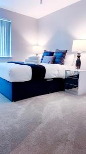 - une chambre avec un grand lit et des oreillers bleus dans l'établissement Foundry luxury new one bedroom apartments close to town center, à Luton