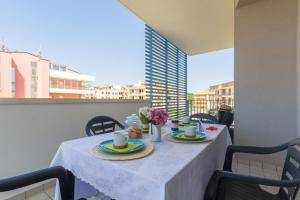 une table avec deux assiettes de nourriture et de fleurs dans l'établissement Appartamento Calipso - MyHo Casa, à Tortoreto Lido