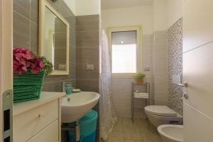 La salle de bains est pourvue d'un lavabo, de toilettes et d'une fenêtre. dans l'établissement Appartamento Calipso - MyHo Casa, à Tortoreto Lido