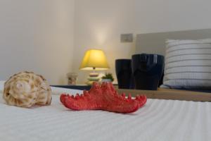 a red starfish on a bed next to a lamp at Appartamento Calipso - MyHo Casa in Tortoreto Lido