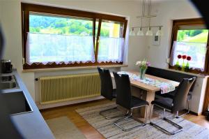 ein Esszimmer mit einem Tisch, Stühlen und einem Fenster in der Unterkunft Ferienwohnung Walgaublick in Frastanz