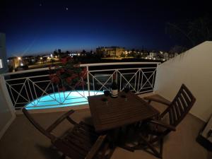 a table and two chairs on a balcony at night at Kato Paphos Suites in Paphos