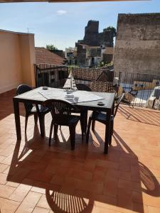 einen Holztisch und Stühle auf einer Terrasse in der Unterkunft Charme in Aci Castello in Aci Castello