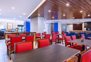 a dining room with tables and red chairs at Holiday Inn Express Tampa-Brandon by IHG in Brandon