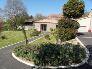 uma entrada com uma casa e um quintal com plantas em Au Petit Bignon em Les Épesses